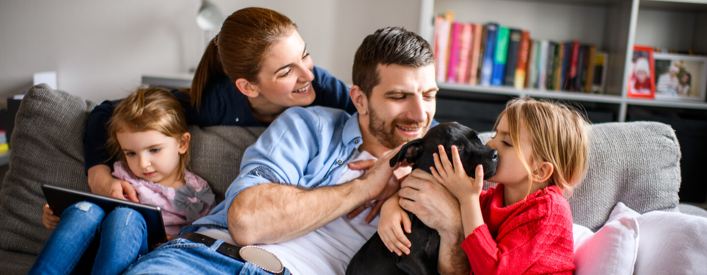 Familia jugando con un cachorro negro