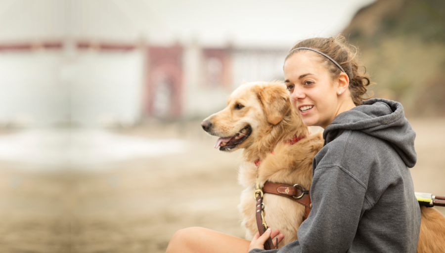 Chica sonriendo y sentada con su perro