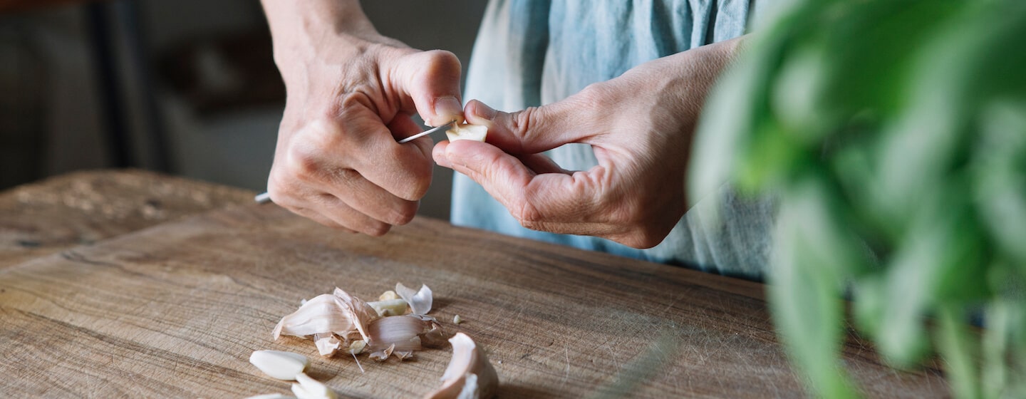 Woman peeling garlic - hero