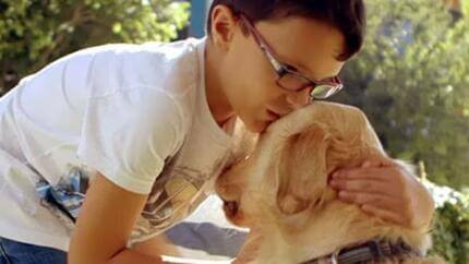 Niño abrazando a un perro de asistencia