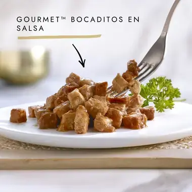 Bocaditos Gourmet en salsa servidos en plato con tenedor y perejil.
