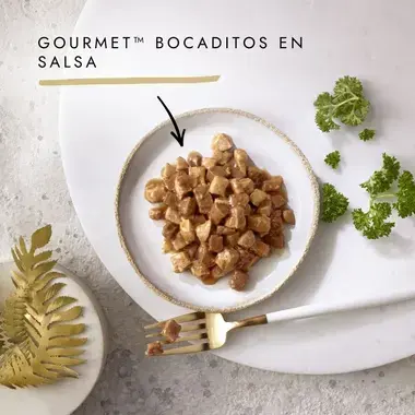 Bocaditos Gourmet en salsa servidos en un cuenco con perejil y tenedor.