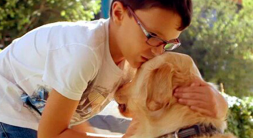 Niño siendo cariñoso con un perro