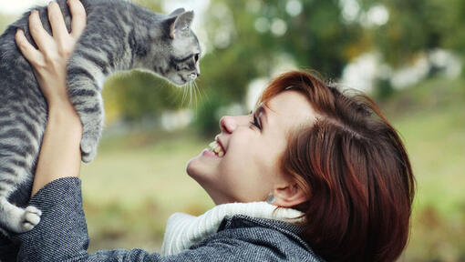 señora sonriendo y mirando a su gato