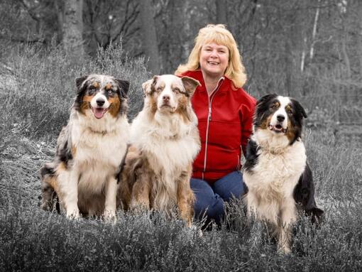 mujer con tres perros en el bosque