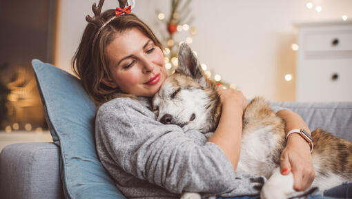 mujer con astas abrazando a su perro dormido